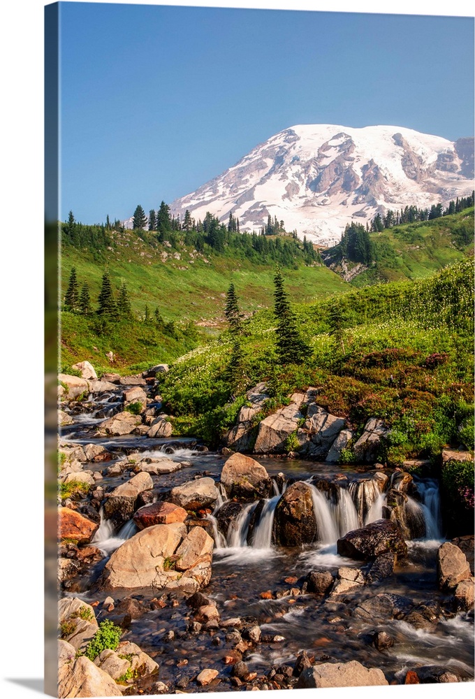 View of a tranquil waterfall with Mount Rainier peak in the background, Mount Rainier National Park, Washington.