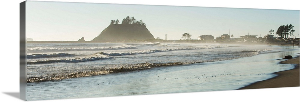 Panoramic landscape photograph of the La Push Beach shore with misty rock cliffs in the background.