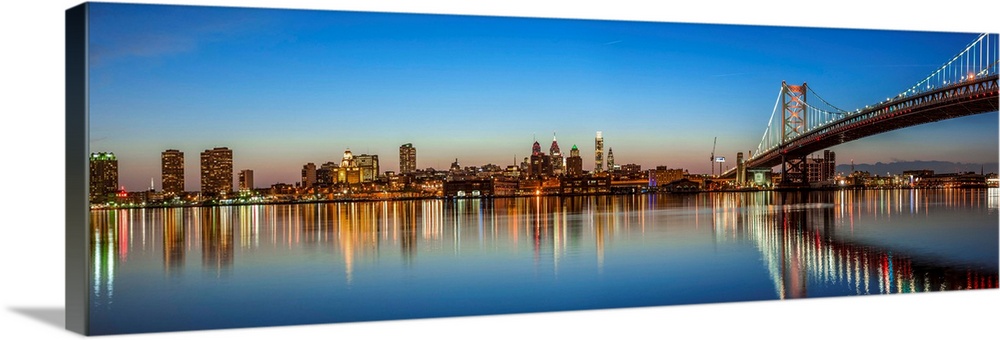 Panoramic view of Philadelphia city skyline at sunset with Ben Franklin Bridge.
