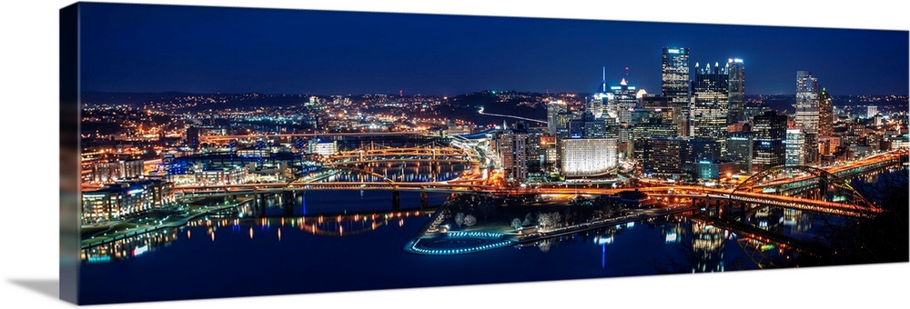 Panoramic photo of downtown Pittsburgh at night with Point State park.