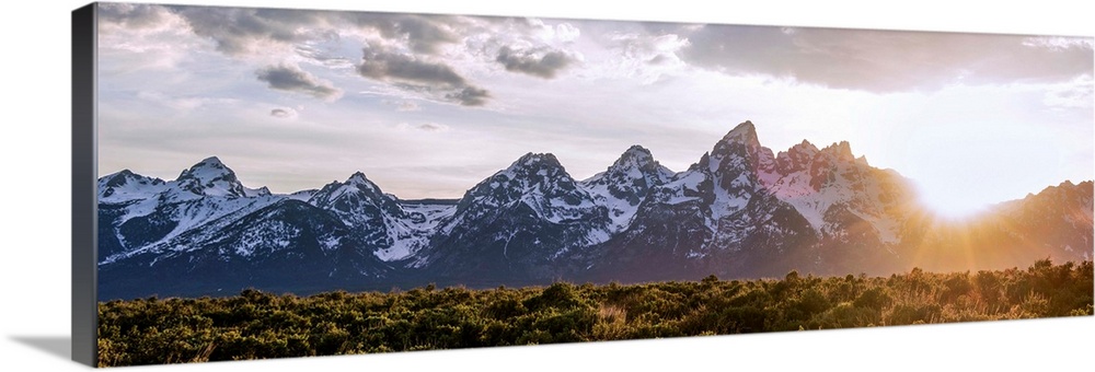 Panoramic view of the sun rising over Teton mountains in Wyoming.