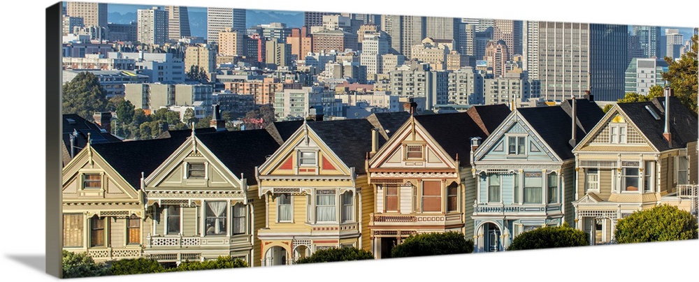 Panoramic photograph of the Painted Ladies in downtown San Francisco with tall buildings in the background.