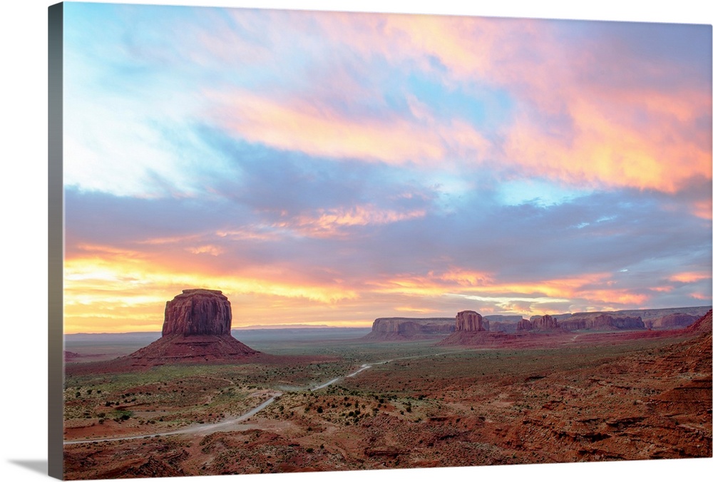 Pastel Sunrise over Merrick Butte and John Ford Point in Monument Valley, Arizona.