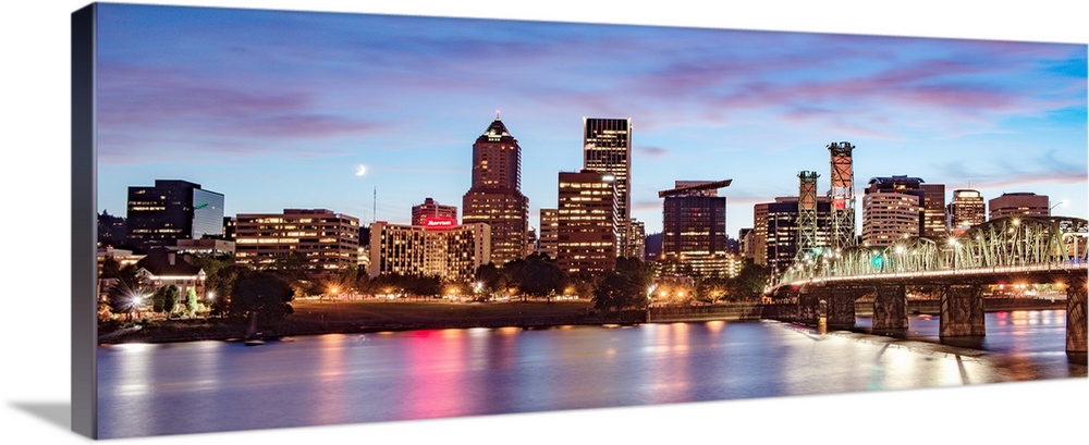 Panoramic photograph of the Portland, Oregon skyline with a purple and pink sunset and a crescent moon above.