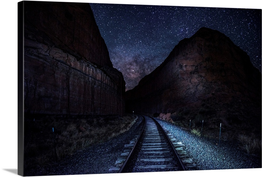 View of railroad tracks at night with a starry sky above near Arches National Park in Utah.