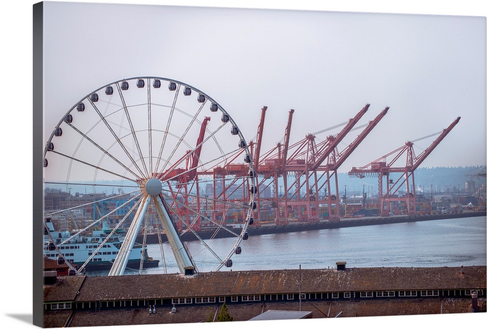 View of Seattle's giant Ferris wheel with dockside cranes in the background in Seattle, Washington.