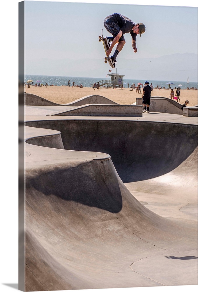 A local skater is in mid-air at Venice's seaside skate park, Los Angeles.