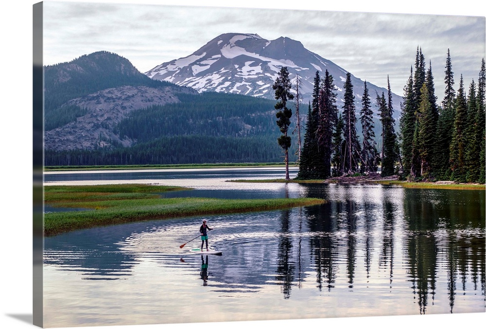 View of a paddle board surfer at Sparks Lake with South Sister peak in the background, Deschutes National Forest in Oregon.