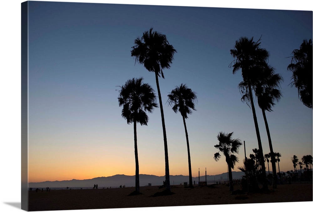 The sun begins to set on Venice beach in California.