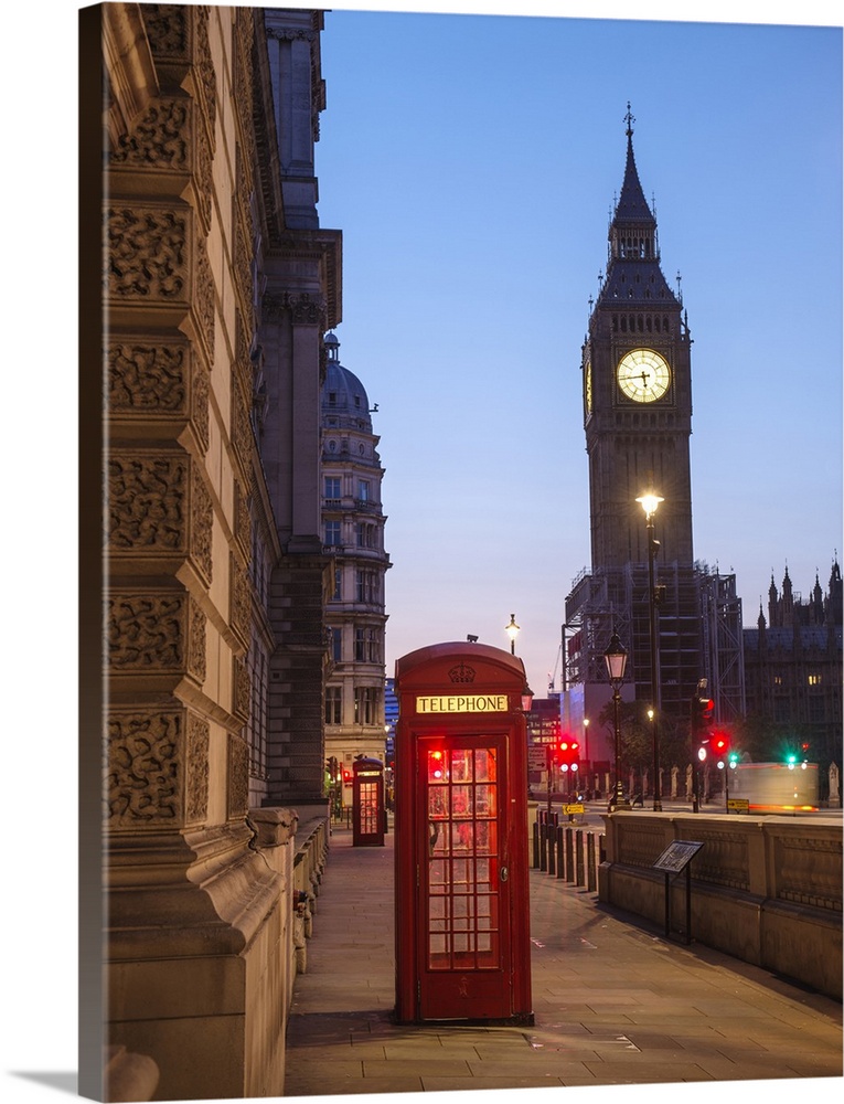 Photograph of a red telephone booth lit up at night with Big Ben in the background.
