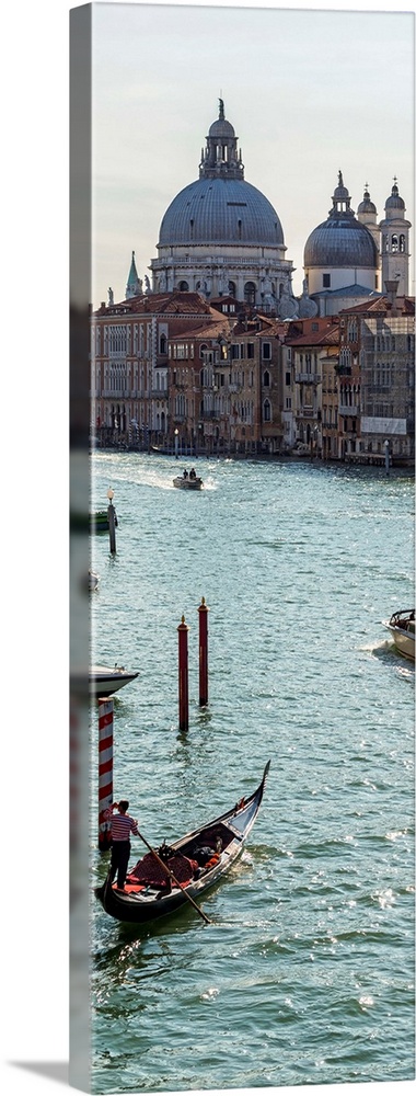 Panoramic photograph of gondolas and boats on the Grand Canal with Santa Maria della Salute in the background.