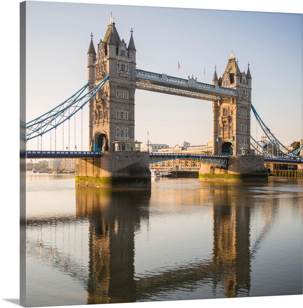 Square photograph of Tower Bridge reflecting into the River Thames in London, England, UK.