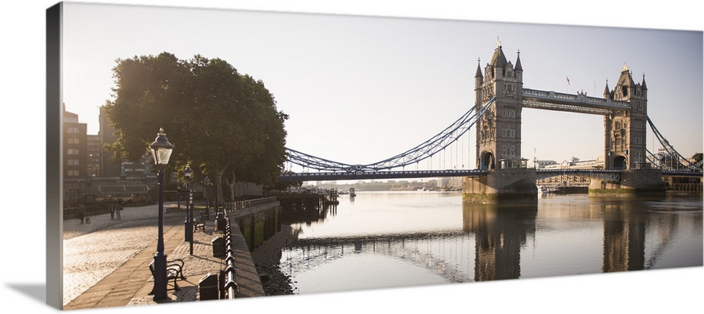 Panoramic photograph of Tower Bridge  reflecting on River Thames with a brick sidewalk on the side.
