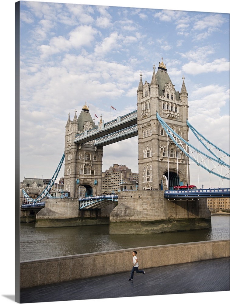 Photograph of Tower Bridge over River Thames with a double decker bus driving through it.