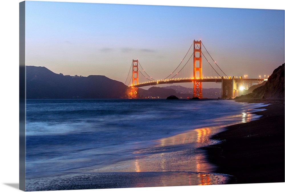 Twilight photograph of the Golden Gate Bridge taken from the shore.