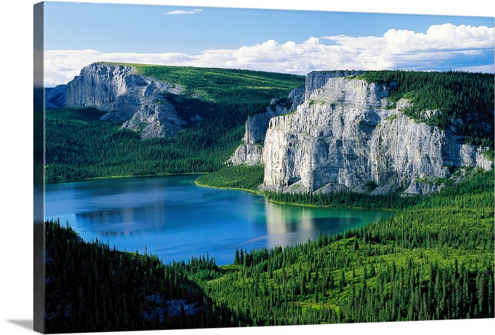 Photograph taken of immense cliffs known as Death Lake. The land is blanketed with trees and the lake sits in the center o...