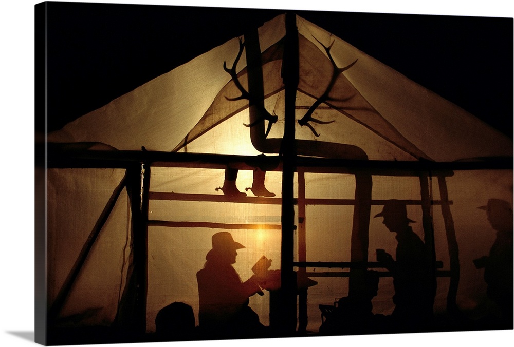 Trail guides spend the night at a camp, their shadows cast against the tent walls