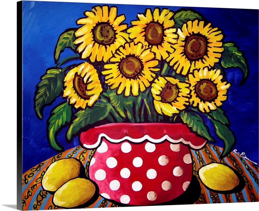 Fun and colorful red polka dotted vase filled with sunflowers. Three lemons sit along side.