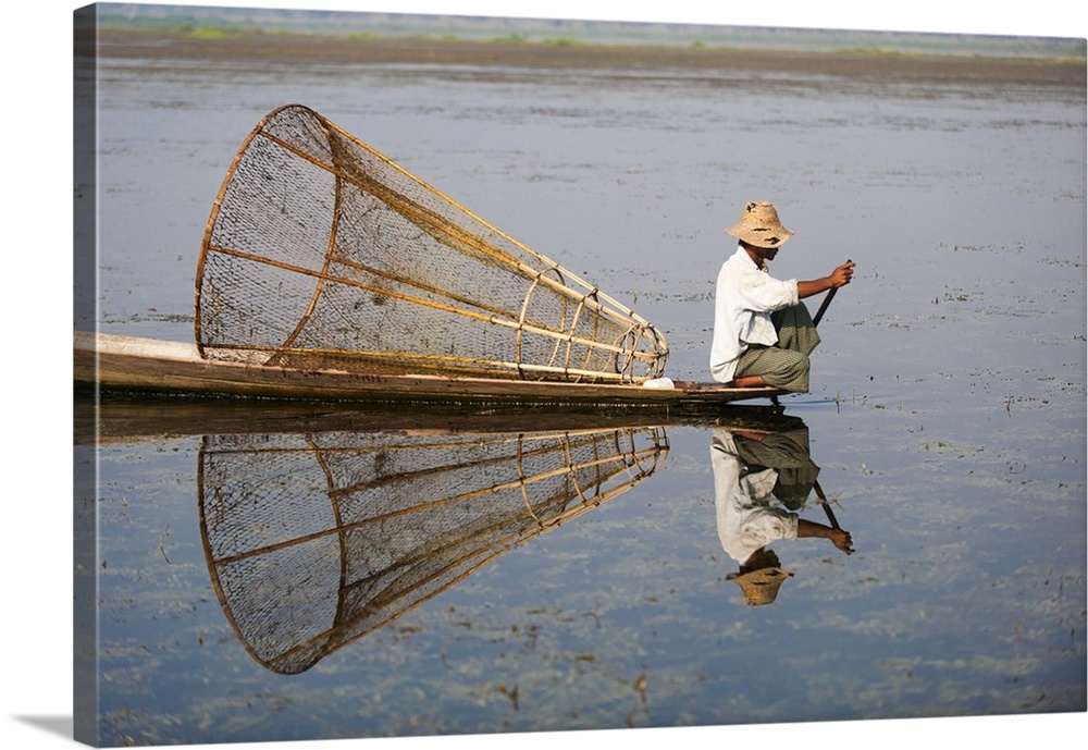 A basket fisherman on Inle Lake scans the still and shallow water for signs of life, Shan State, Myanmar