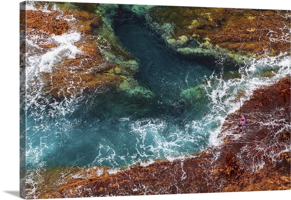 A fisherman fishes a Beryx splendens down a cliff in Fuerteventura island, Canary Islands, Spain, Atlantic