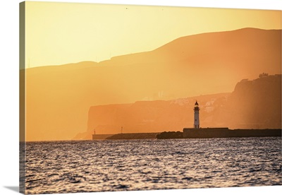 A Lighthouse Stands Against Golden Coastal Cliffs In Almeria, Spain