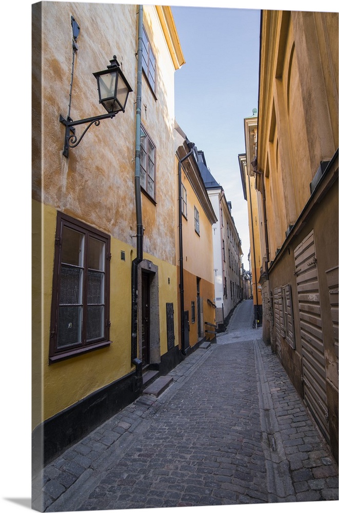 A pedestrian walks the streets of Stockholm's colorful and historic Gamla Stan district, Stockholm, Sweden, Scandinavia, E...