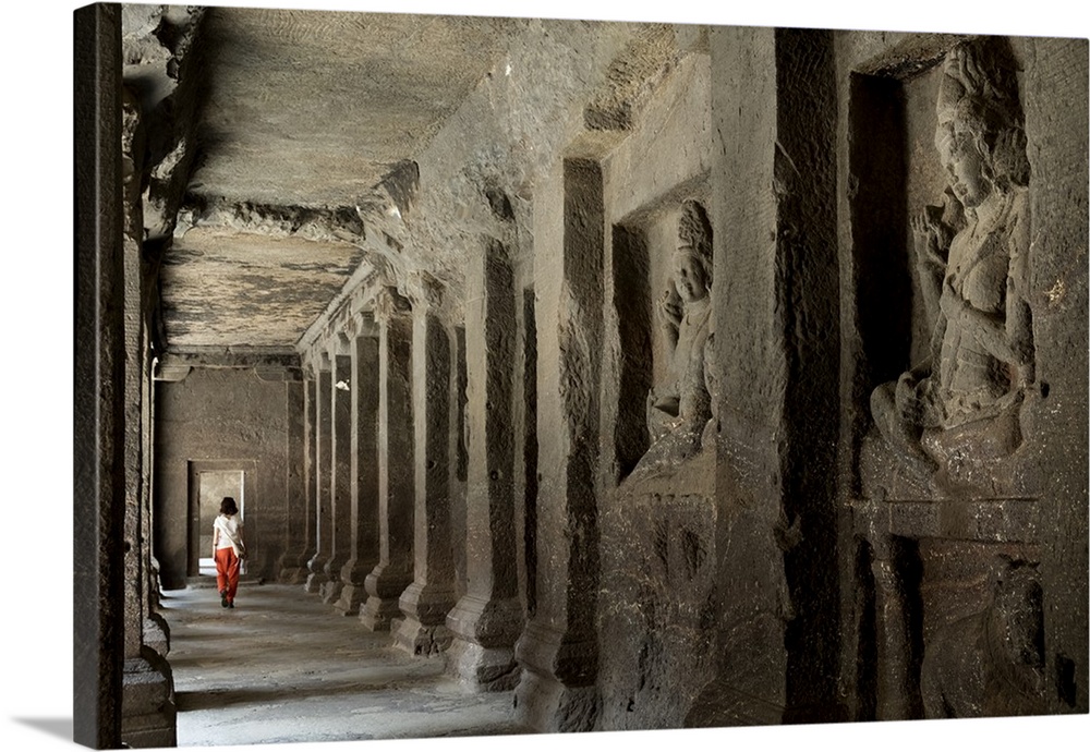 A woman walking through a corridor in the Hindu temple in the Kailash cave temple, Ellora