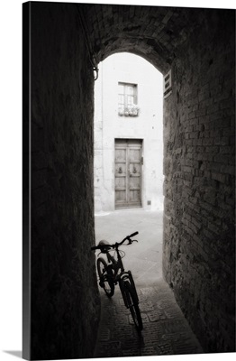 Bicycle in shady alleyway, San Quirico d'Orcia, Tuscany, Italy