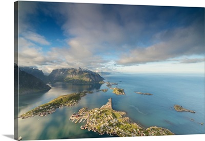 Blue sky and clouds frame the turquoise sea and the typical village, Norway