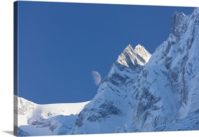 Blue sky and moon on the snowy ridges of the high peaks, Soglio, Bregaglia Valley