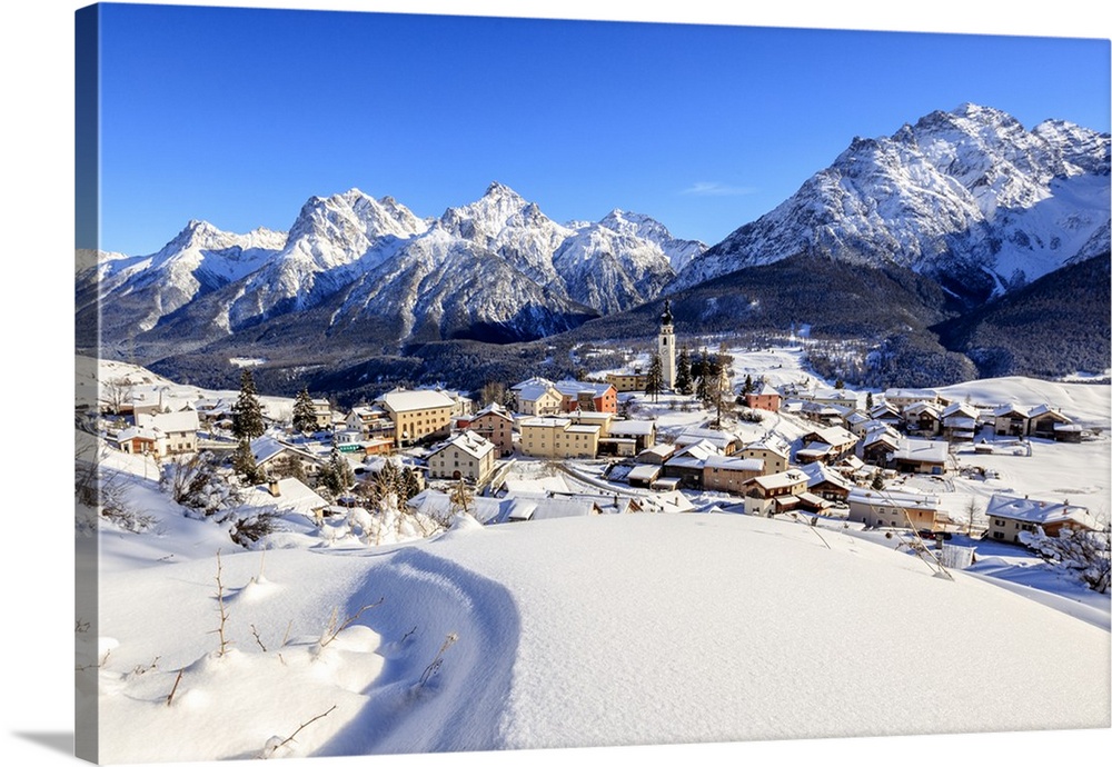 Blue sky on the alpine village of Ftan surrounded by snow, Inn district, Canton of Graubunden, Engadine, Swiss Alps, Switz...