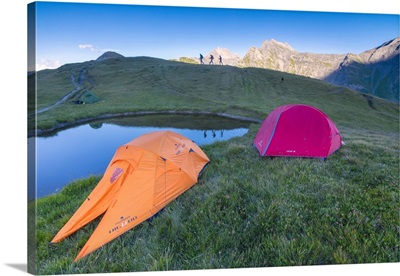 Camping tents and hikers with Mont De La Saxe on the background, Courmayeur, Italy