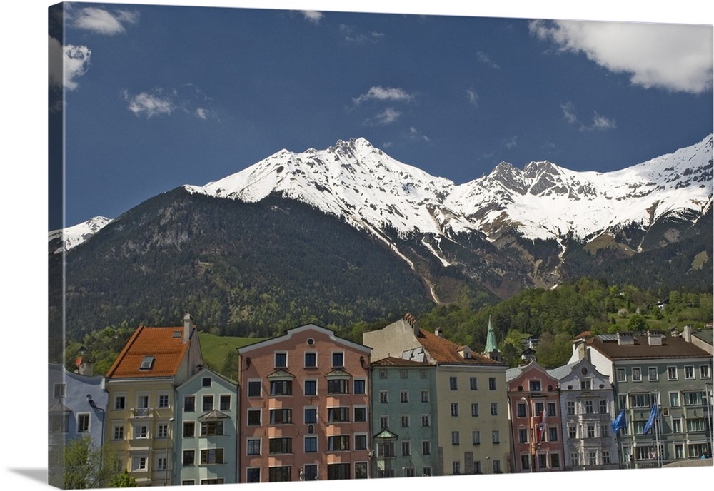 Candy coloured houses with backdrop of mountains in spring snow, Innsbruck, Austria