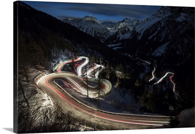 Car lights on the curvy Maloja Pass road, Engadine, Switzerland