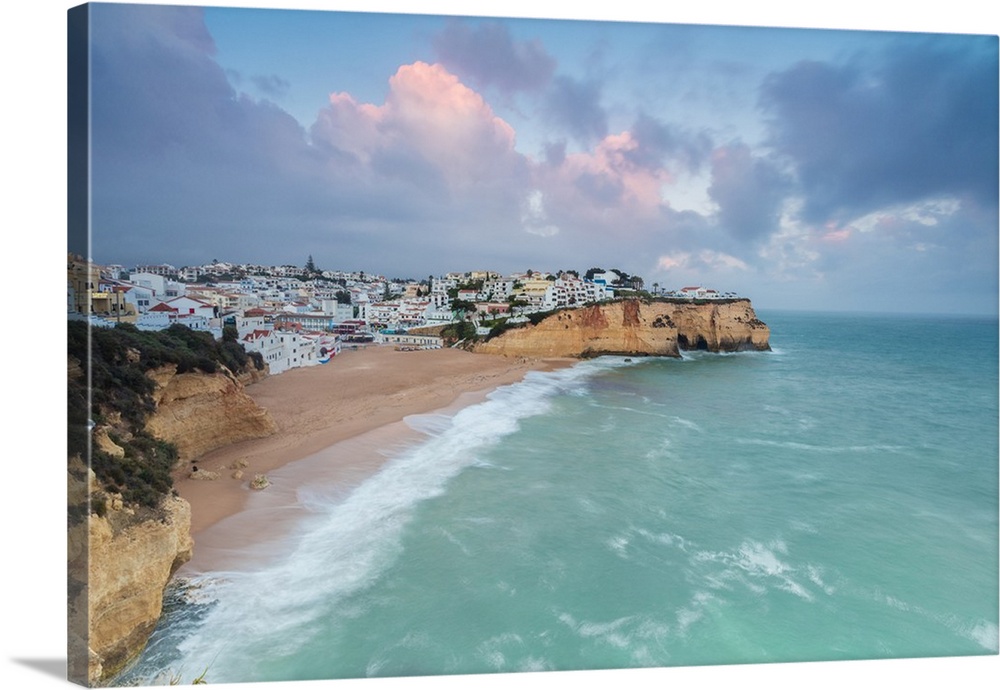 View of Carvoeiro village surrounded by sandy beach and turquoise sea at sunset, Lagoa Municipality, Algarve, Portugal