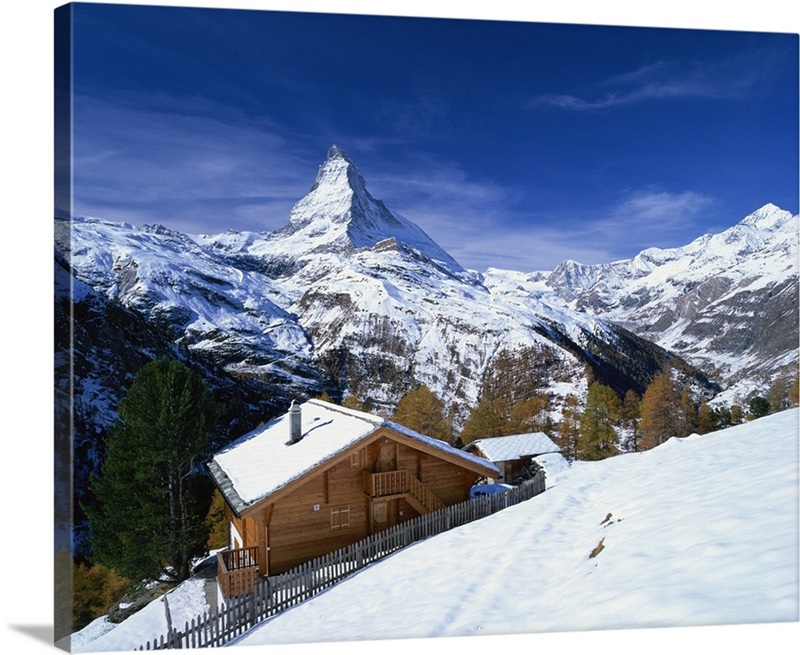 Chalets in a snowy landscape with the Matterhorn peak, Swiss Alps ...