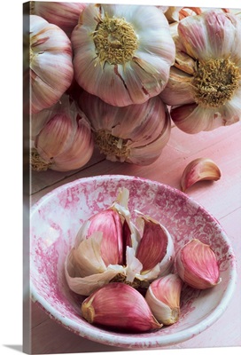 Close-up of cloves of garlic in a pink bowl