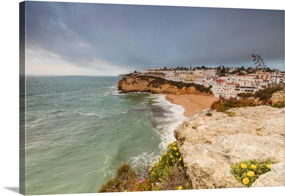 Clouds on Carvoeiro village surrounded by sandy beach and turquoise sea, Lagoa Municipality, Algarve, Portugal