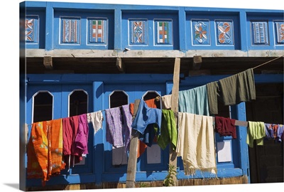 Colourful laundry hanging in front of blue traditional house, village of Kalpa, India
