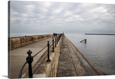 Couple walking on the North Pier at Tynemouth, North Tyneside, Tyne and Wear, England