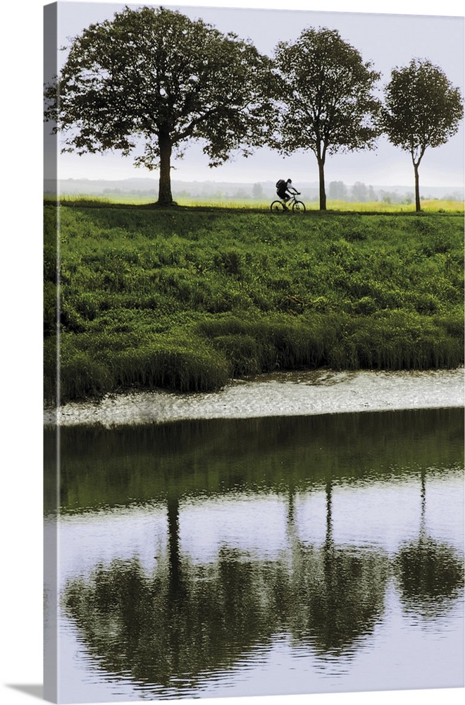 Cyclist on banks of River Somme, St. Valery sur Somme, Picardy, France