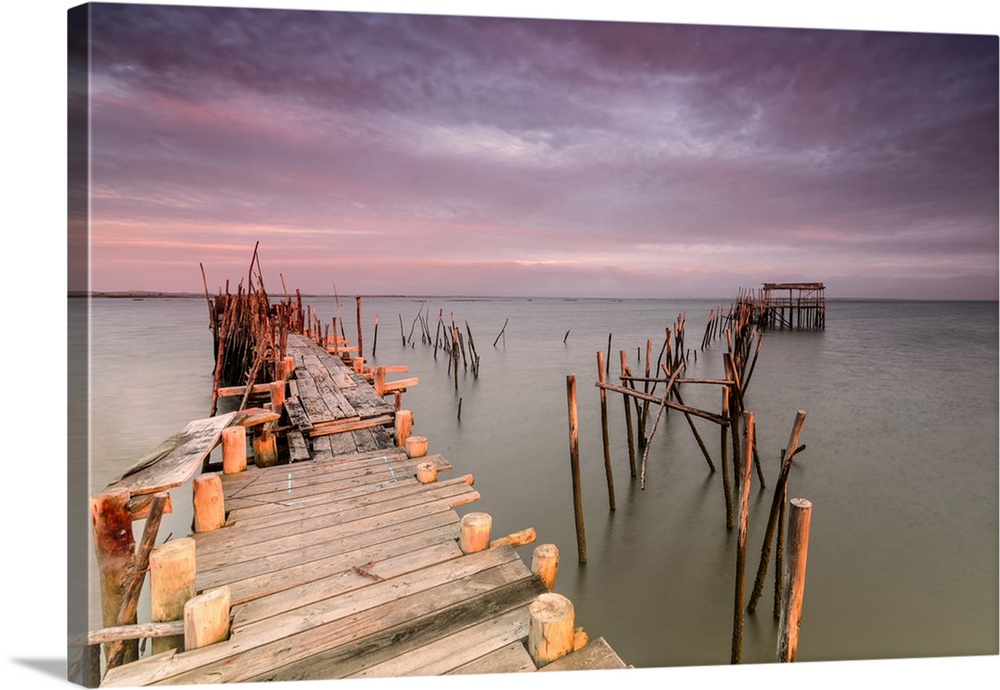 Pink sky at dawn on the Palafito Pier in the Carrasqueira Natural Reserve of Sado River, Alcacer do Sal, Setubal, Portugal