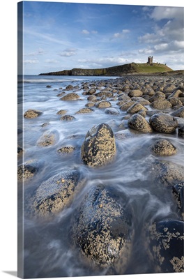Dunstanburgh Castle From The Rocky Shores Of Embleton Bay, Northumberland, England, UK