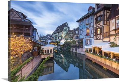 Dusk lights on houses reflected in River Lauch at Christmas, France