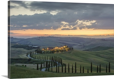 Dusk on green hills surrounded by cypresses and farm houses, Tuscany, Italy