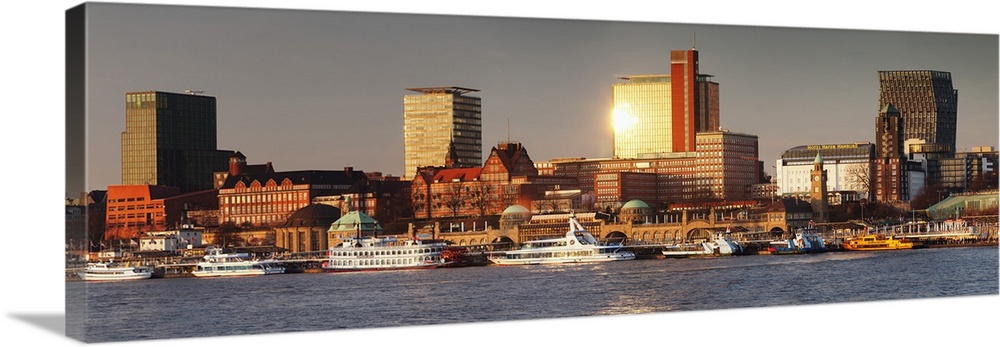 View from Elbe River to St. Pauli Landungsbruecken pier and skyscraper Tanzende Tuerme at sunset, St. Pauli, Hamburg