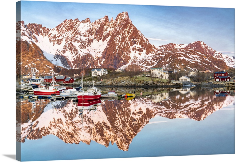 Fishing boats and snowcapped mountains mirrored in the fjord at sunrise, Ballstad, Vestvagoy, Lofoten Islands, Norway, Sca...