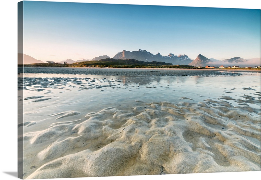 High peaks and midnight sun are reflected in the cold sea, Fredvang, Moskenesoya, Nordland county, Lofoten Islands, Norway...