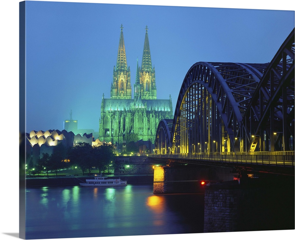 Hohenzollernbrucke and the Cathedral Illuminated at Night, Cologne, Germany.