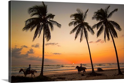 Horse riders at sunset, Playa Guiones surfing beach, Costa Rica
